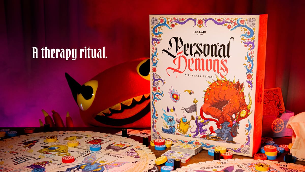 Verpackung von Personal Demons auf einem Spieltisch mit ausgelegten Karten und bunten Wertungsmarkern, im Hintergrund eine plüschartige rote Dämonenfigur, dramatisch rot beleuchtete Szene